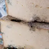Dos bloques de queso apilados, con moho azul visible, sugieren que es queso en mal estado.