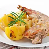 Conejo al horno jugoso con patatas asadas y romero fresco. Un plato tradicional y delicioso.