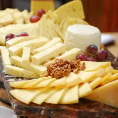 Tabla de quesos variados, cortados en diferentes formas para una presentación ideal. Aprende como cortar quesos para tablas y disfruta de esta delicia.