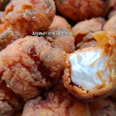 Trozos dorados y crujientes de cazon en adobo, listos para disfrutar. Uno muestra su interior blanco y tierno.