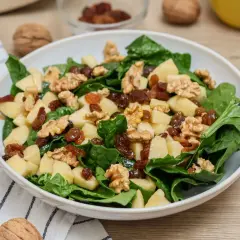 Deliciosa ensalada de espinacas con trozos de manzana, pasas y nueces. Una combinación crujiente y dulce.