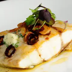 Filete de corvina con mantequilla de hierbas y aceitunas negras, una de las corvina recetas gourmet.