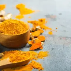 Raíces de cúrcuma y polvo vibrante. La cúrcuma es curry, esencial para dar color y sabor a tus platos.