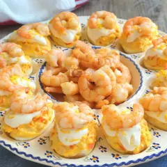 Huevos rellenos decorados con gambas y una pizca de ralladura de huevo. Un aperitivo delicioso y vistoso.