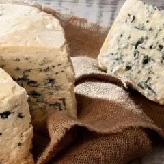 Queso azul con vetas oscuras sobre arpillera. Sus propiedades son únicas para realzar sabores.