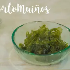 Un cuenco de cristal verde contiene pimiento de mar fresco y brillante.