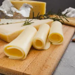 Variedad de quesos, incluyendo uno azul y rollos de queso amarillo. ¡Cuidado, el queso tiene lactosa!