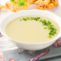 Crema suave de parmentier de patata, decorada con cebollino fresco. Un plato reconfortante listo para disfrutar.