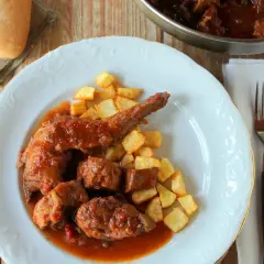 Plato de conejo guisado con patatas fritas. Un delicioso plato casero que invita a disfrutar.