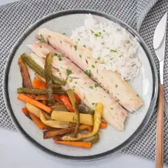 Deliciosa lubina a la sal servida con arroz blanco y verduras asadas. Un plato saludable y lleno de sabor.