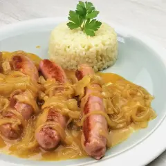 Salchichas al vino con cebolla caramelizada y una porción de arroz blanco, decorado con perejil.