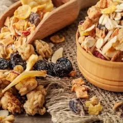Un tazón de madera lleno de muesli, una mezcla de avena, frutos secos y cereales. El muesli es un desayuno saludable y energético.