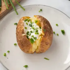 Patatas asadas crujientes rellenas de crema agria y cebollino fresco. Un plato sencillo y delicioso.
