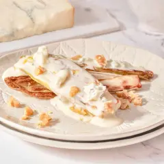 Endivias gratinadas con salsa cremosa, trozos de gorgonzola y nueces crujientes.