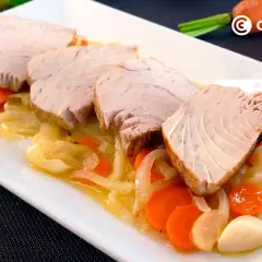 Rodajas de bonito jugoso sobre cama de cebolla y zanahoria. Una de las mejores recetas con bonito para disfrutar.