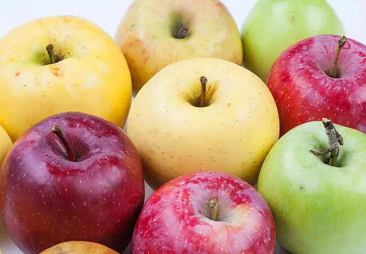 Variedad de manzana tipos: rojas, verdes y amarillas, dispuestas en un grupo.