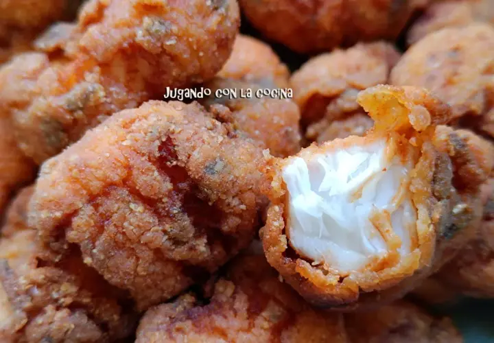 Trozos dorados y crujientes de cazon en adobo, listos para disfrutar. Uno muestra su interior blanco y tierno.