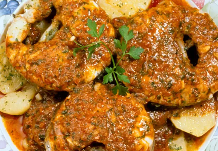 Merluza a la gallega, jugosa y sabrosa, servida con patatas y perejil fresco.