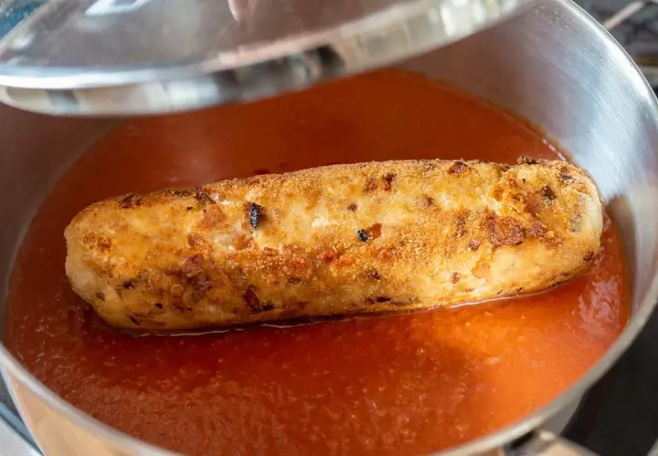 Rollo de bonito dorado y crujiente nadando en una salsa de tomate casera, listo para ser servido.