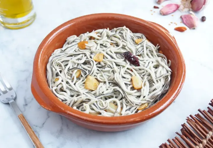 Un cuenco de barro con gulas al ajillo, salteadas con ajo y guindilla. Un plato tradicional español.