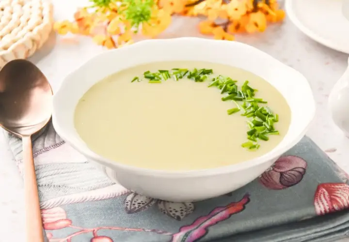 Crema suave de parmentier de patata, decorada con cebollino fresco. Un plato reconfortante listo para disfrutar.