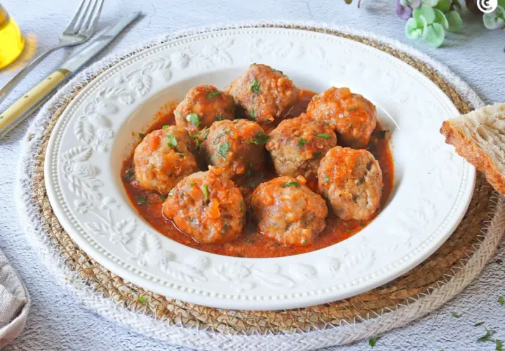 Albóndigas en salsa de la abuela, jugosas y caseras, servidas en un plato blanco con un borde decorado. Un clásico reconfortante.