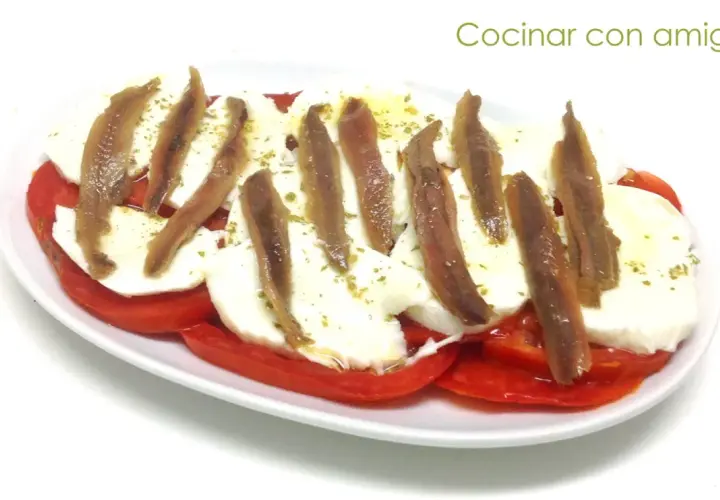 Ensalada caprese con anchoas, un toque salado que realza el sabor fresco de los tomates y la mozzarella. ¡Perfecta para compartir!