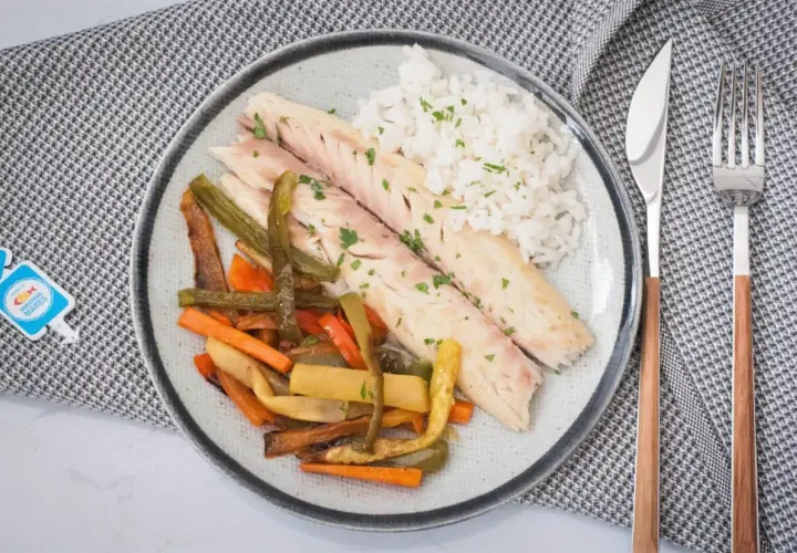 Deliciosa lubina a la sal servida con arroz blanco y verduras asadas. Un plato saludable y lleno de sabor.