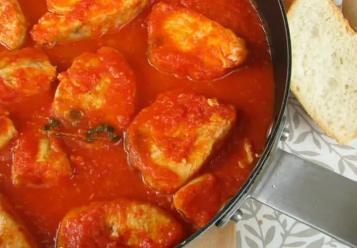 Bonito en salsa de tomate, un plato casero con trozos de pan.