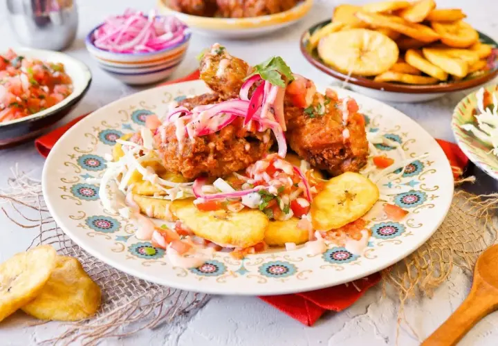 Pollo chuco crujiente con plátanos fritos, pico de gallo y cebolla morada encurtida. ¡Un festín de sabores!