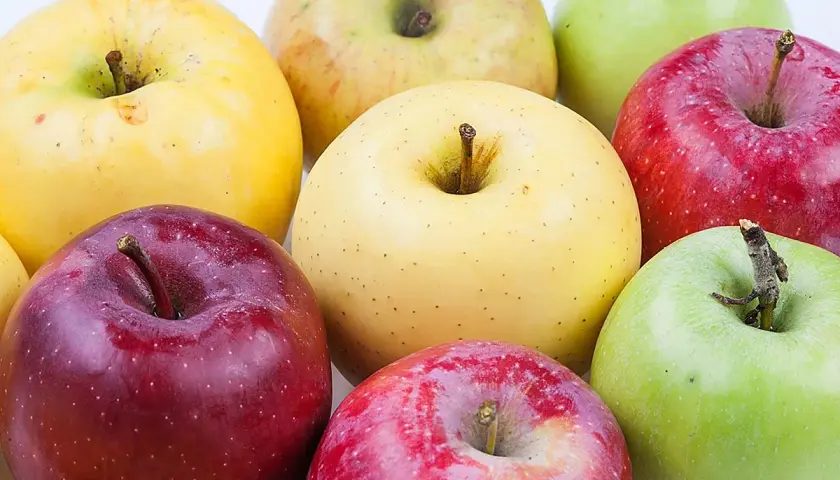 Variedad de manzana tipos: rojas, verdes y amarillas, dispuestas en un grupo.