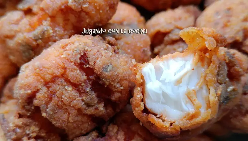 Trozos dorados y crujientes de cazon en adobo, listos para disfrutar. Uno muestra su interior blanco y tierno.