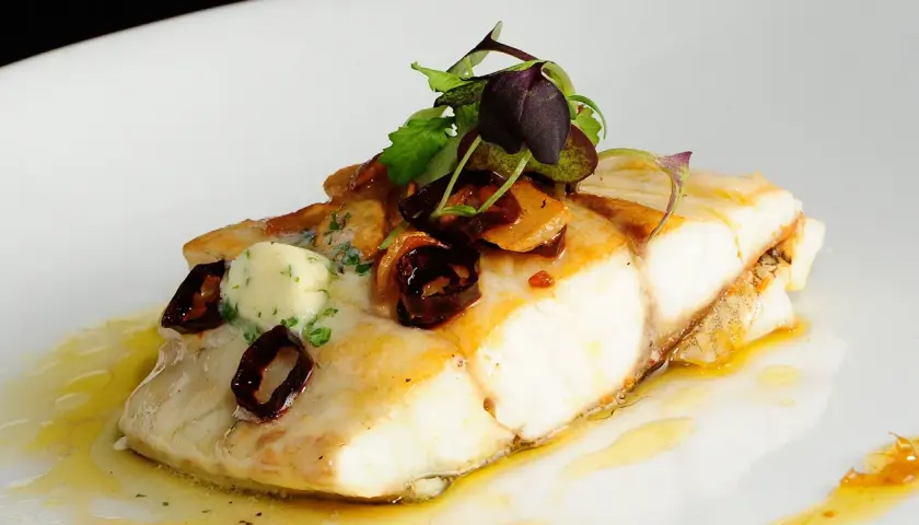 Filete de corvina con mantequilla de hierbas y aceitunas negras, una de las corvina recetas gourmet.