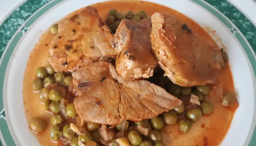 Guisantes con atún en salsa roja, un plato casero que huele delicioso.