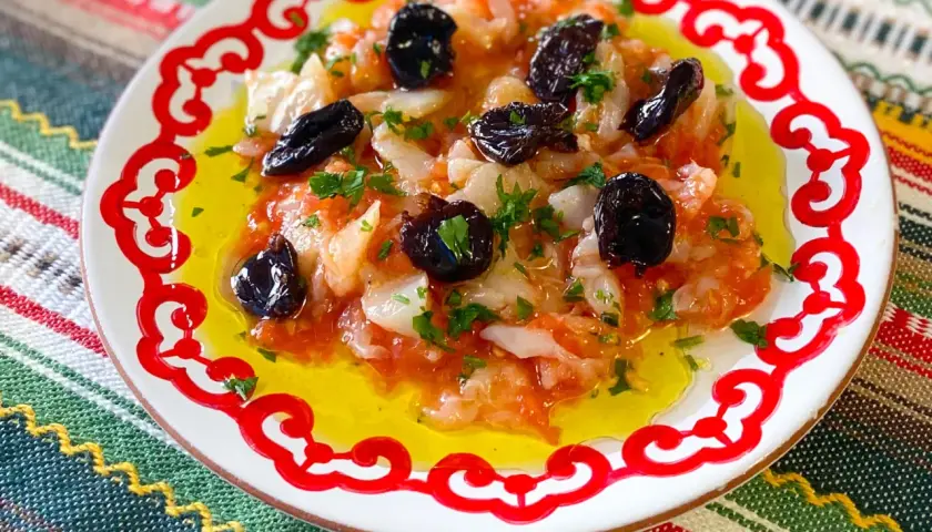 Plato con bacalao desmigado, aceitunas negras y perejil, bañado en aceite de oliva. Una de las muchas recetas de bacalao.