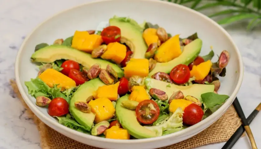 Deliciosa ensalada de mango con aguacate, tomates cherry y pistachos. Fresca y colorida, perfecta para cualquier ocasión.