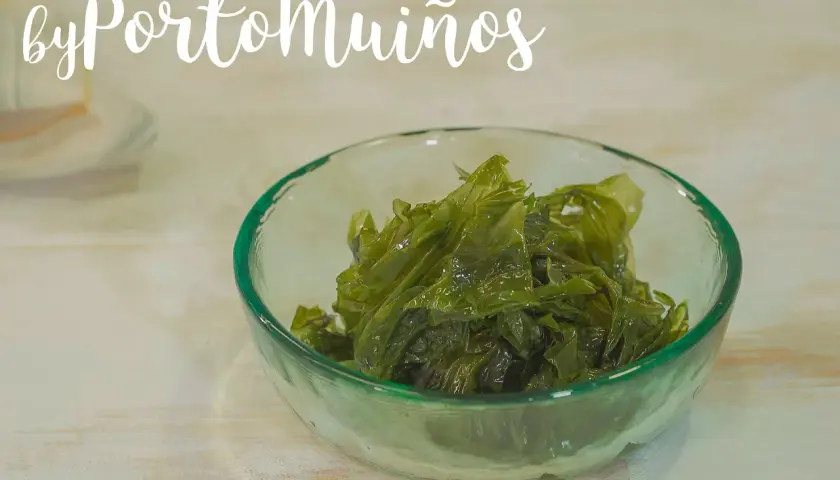 Un cuenco de cristal verde contiene pimiento de mar fresco y brillante.
