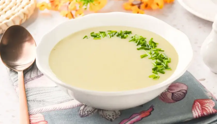 Crema suave de parmentier de patata, decorada con cebollino fresco. Un plato reconfortante listo para disfrutar.