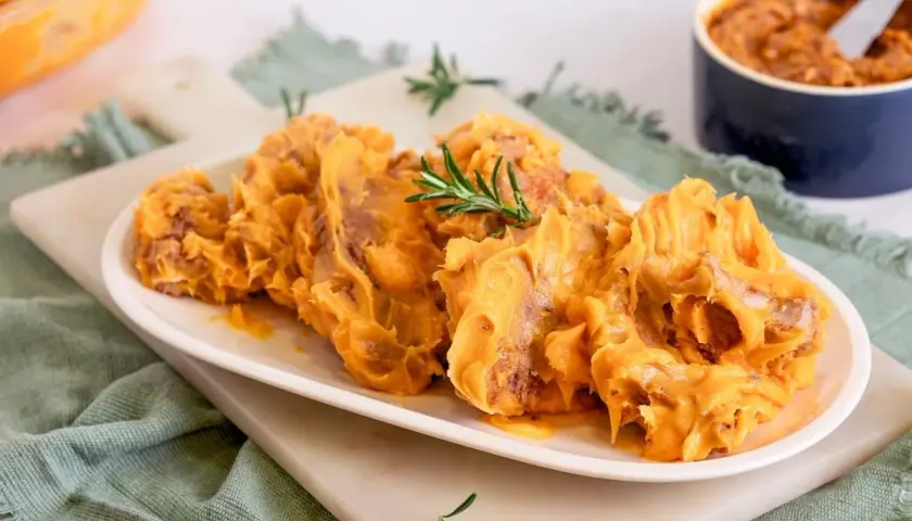 Delicioso lomo en manteca, servido en plato blanco con romero. Un manjar cremoso y apetitoso.