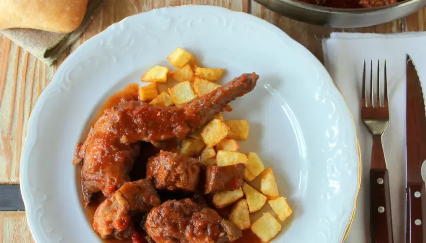 Plato de conejo guisado con patatas fritas. Un delicioso plato casero que invita a disfrutar.