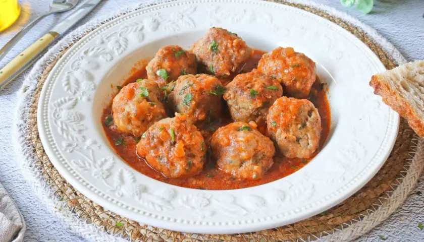 Albóndigas en salsa de la abuela, jugosas y caseras, servidas en un plato blanco con un borde decorado. Un clásico reconfortante.