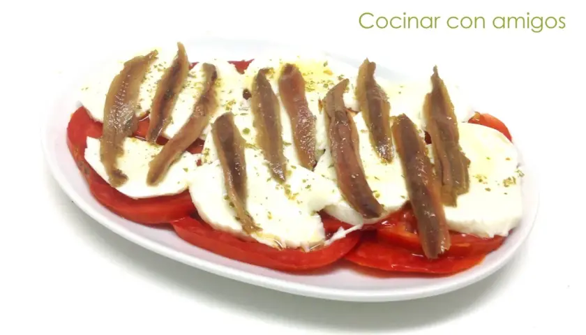 Ensalada caprese con anchoas, un toque salado que realza el sabor fresco de los tomates y la mozzarella. ¡Perfecta para compartir!