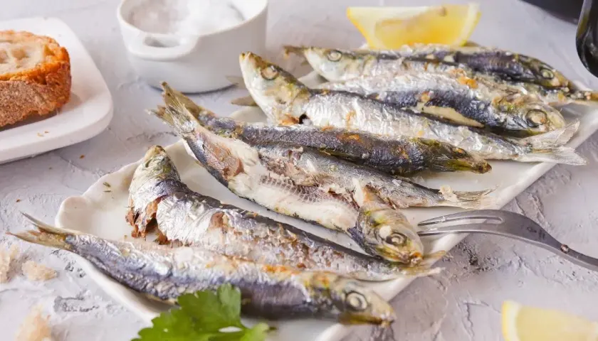 Sardinas empanadas, doradas y crujientes, servidas con limón y pan. Un plato delicioso y saludable.