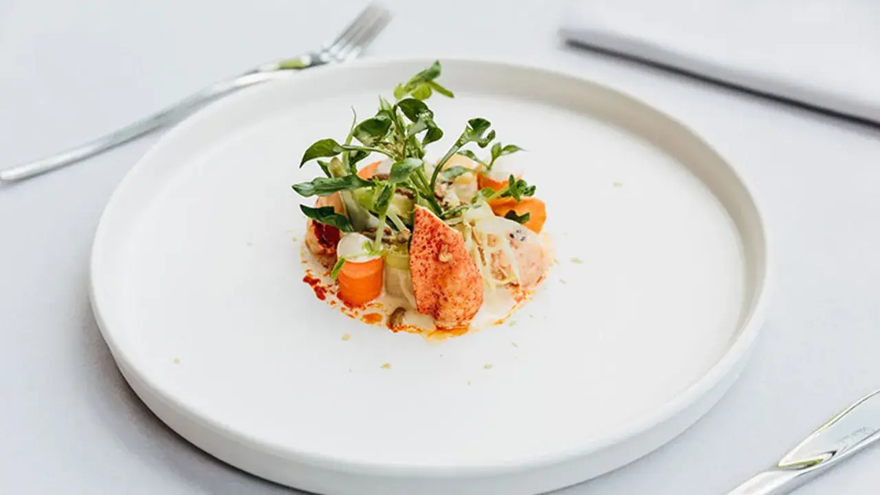 Exquisita ensalada de bogavante gourmet con verduras frescas y una cremosa salsa.