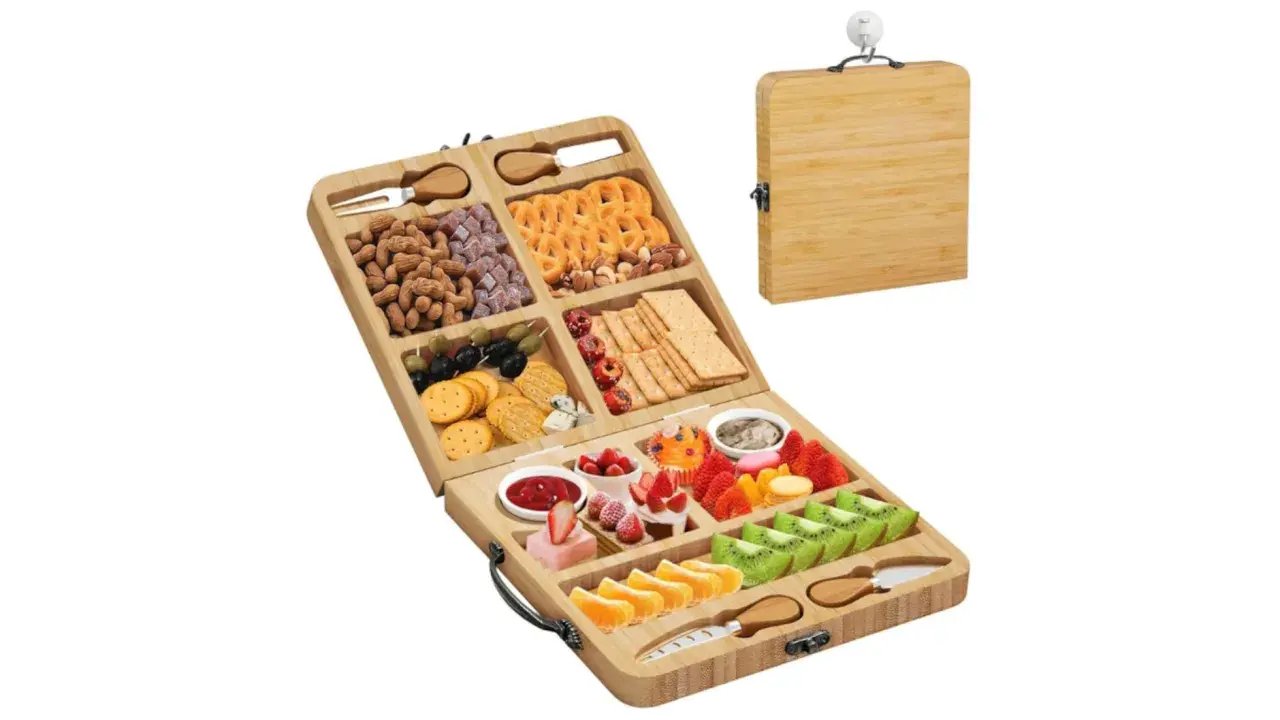 Tabla de bambú abierta con variedad de quesos, frutos secos, galletas y frutas frescas como fresas, kiwi y naranjas.