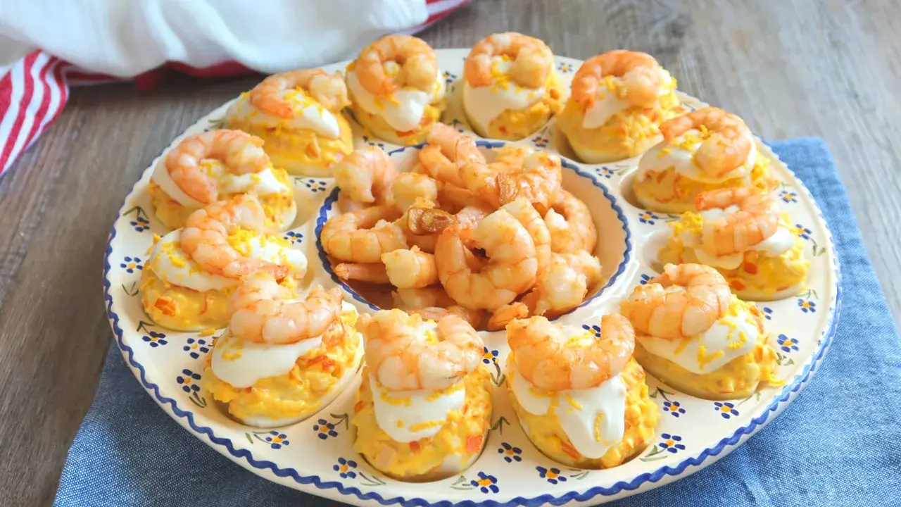 Huevos rellenos decorados con gambas y una pizca de ralladura de huevo. Un aperitivo delicioso y vistoso.