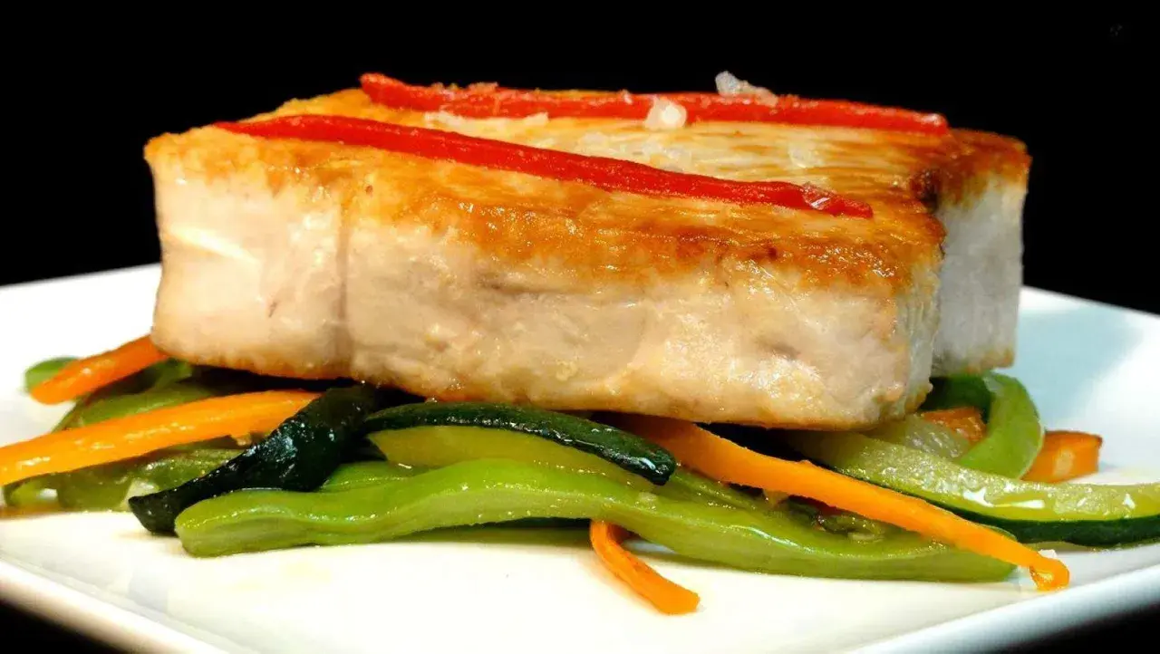 Bonito jugoso con pimientos rojos y verduras salteadas. Un plato perfecto para aprender como cocinar el bonito para que quede jugoso.