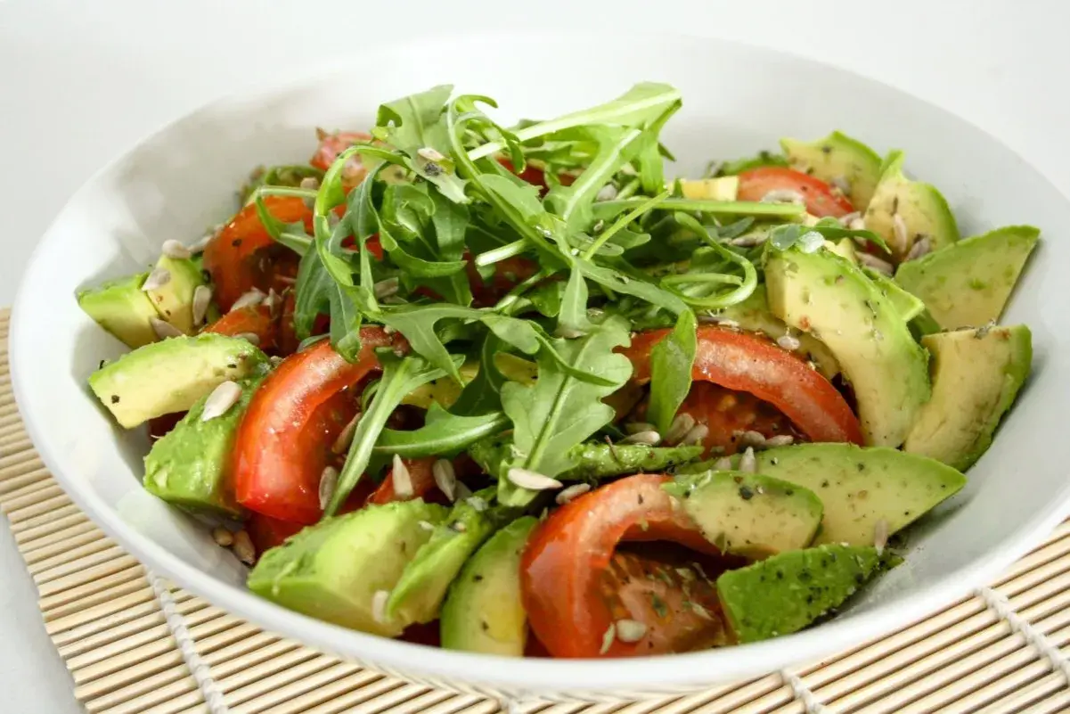 Ensalada fresca con aguacate, tomate y rúcula. Perfecta para tus recetas con aguacate.