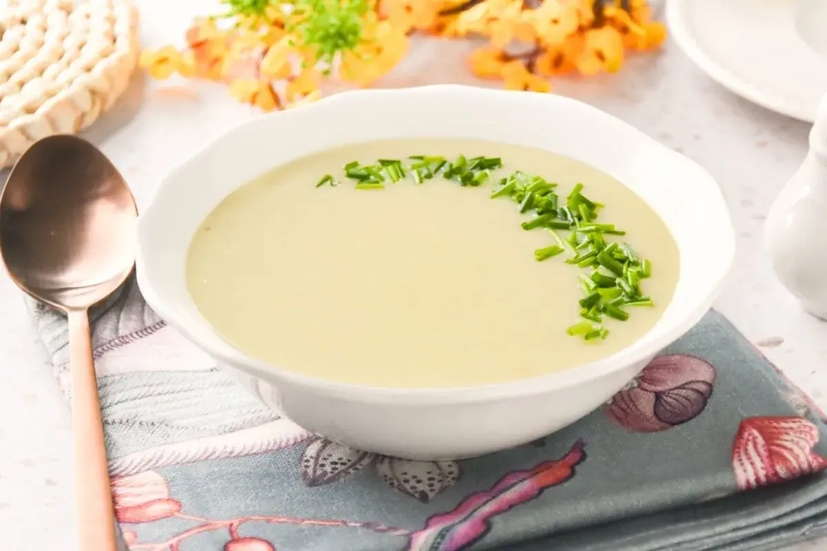 Crema suave de parmentier de patata, decorada con cebollino fresco. Un plato reconfortante listo para disfrutar.