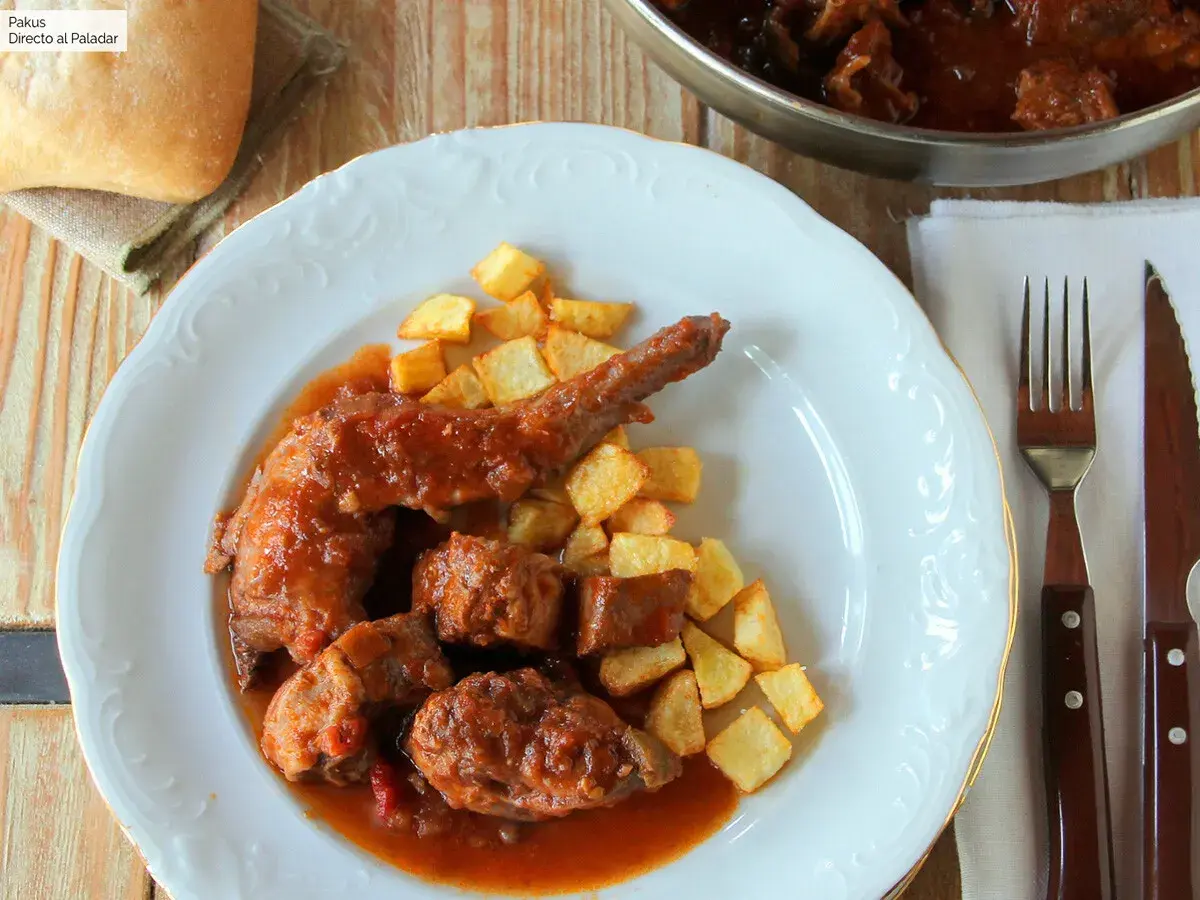 Plato de conejo guisado con patatas fritas. Un delicioso plato casero que invita a disfrutar.